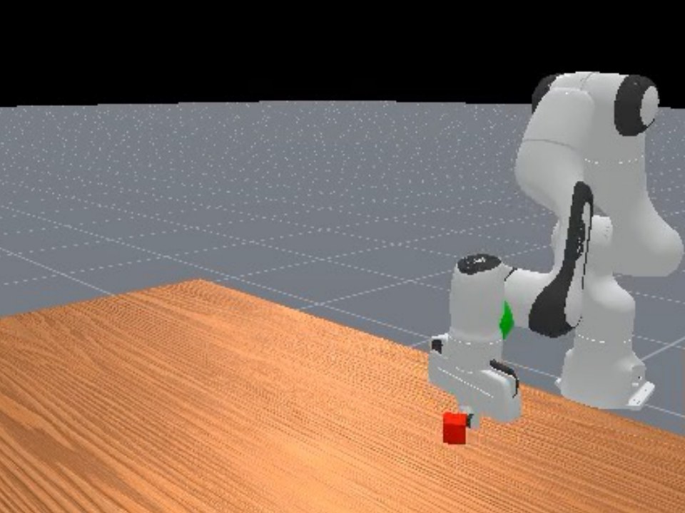 Franka arm and a red cube on a wooden table in ManiSkill simulation